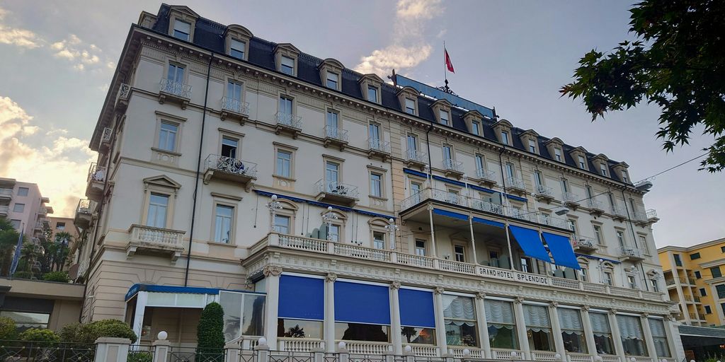 A large hotel building with blue shutters and windows